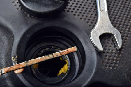 The thick, greasy yellow motor oil under oil cap as signs and symptom of a blown head gasket. Broken a carの写真素材