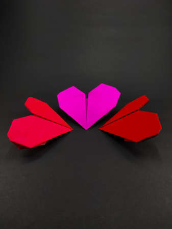 Multi colored heart shaped origami paper isolated on black background, not in focus