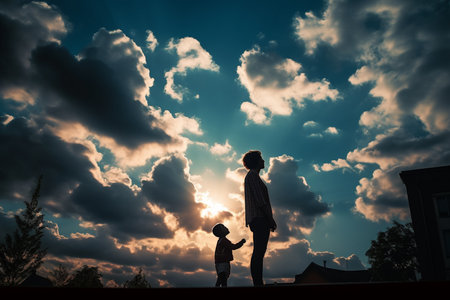 Silhouette of mother and son on the roof at sunset.の素材