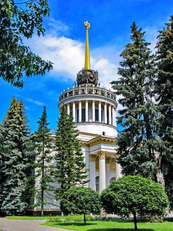 A building with a high tower and columns in the Gothic style. Around the pine and the blue skyの写真素材