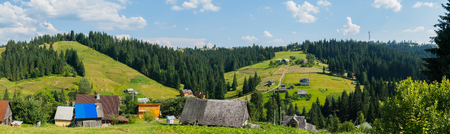 panorama of Transcarpathian village surrounded by coniferous forestの写真素材