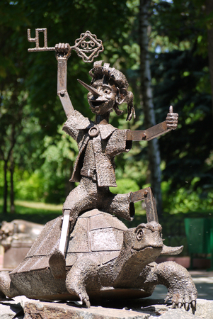 metal balloon known for the fairy tale hero Pinocchio with a golden clutch riding on a turtleの写真素材