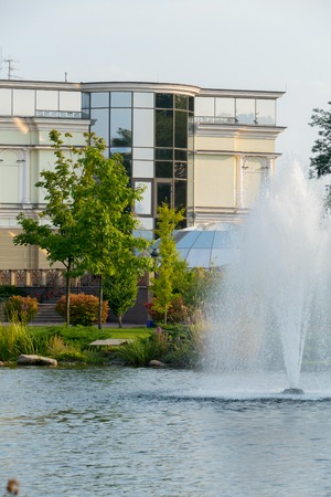 a municipal office building with an excellent pond near and a fountain in the middle of itの写真素材