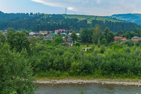 the flow of the river with stony shores near the resort town, located at the foot of the hillの写真素材