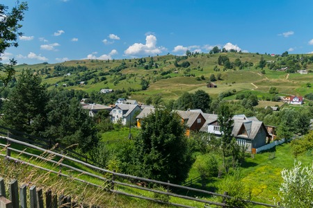 the street of the Carpathian village on the valley with a dense number of buildingsの写真素材