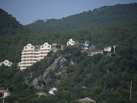 A large hotel on the background of green rocky mountains and a boundless blue skyのeditorial素材