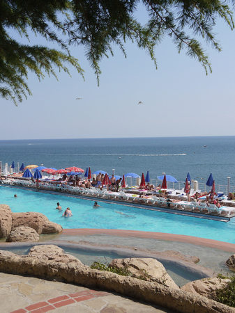 Swimming pool with tourists near the beach in the background of the endless blue skyのeditorial素材