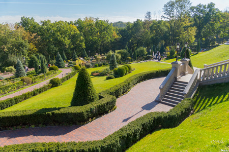 A picturesque landscape of a green park located on the slopes with stairs paths and a diverse floraの写真素材