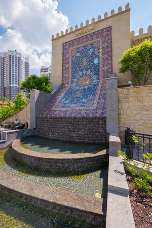 A small decorative cascading fountain near the wall, which depicts an Azerbaijani carpetのeditorial素材