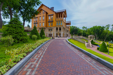 The alley is decorated by hosts leading to a beautiful large wooden house with balconies. Novi Petrivtsi, Ukraineのeditorial素材