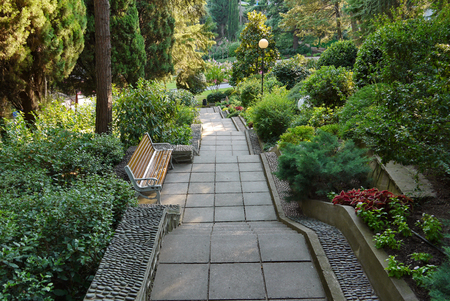 A staircase with steps and flower beds around, among the green park, and around are lanternsの写真素材