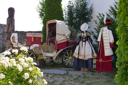 Middle-aged clothes with interesting embroidery for men and women against the backdrop of an old carriageのeditorial素材