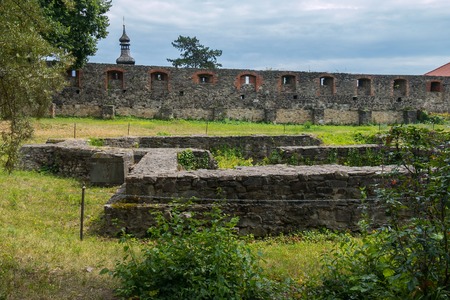 walls of an old fortress with loopholes made of stone against the sky and a dome of a tower with a spireのeditorial素材
