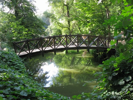 wooden bridge with railings above the river in the park under the trees. Uman Ukraineの写真素材