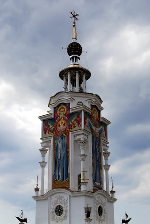 A beautiful high church building with saints' faces on the walls with a dome and beautiful architecture against a sky with clouds.の写真素材