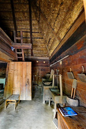 A small wooden hangar with a straw roof in which the working tools are storedの写真素材