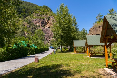 A number of wooden gazebos on the clean area of the recreation complex with a beautiful view on the rockの写真素材