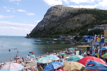 A sandy beach and a mountain creating a shadow over it and the sea. An ideal place for a curretのeditorial素材
