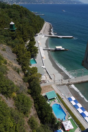A beautiful view from the top of the coastal strip with an empty beach neat pool and outgoing quays in the sea.のeditorial素材