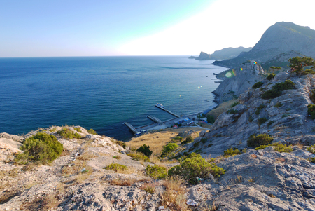 View of the endless sea-surface horizon from the top of a rocky mountain near the pierの写真素材