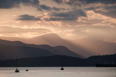 Sunset over mountains and the oceanの写真素材