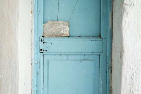 Old house with vintage wooden blue cyan door and white wallの写真素材