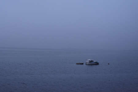 Boat on a lake on a foggy dayの写真素材