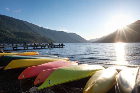 Colourful canoes laying next to a beautiful lakeの写真素材