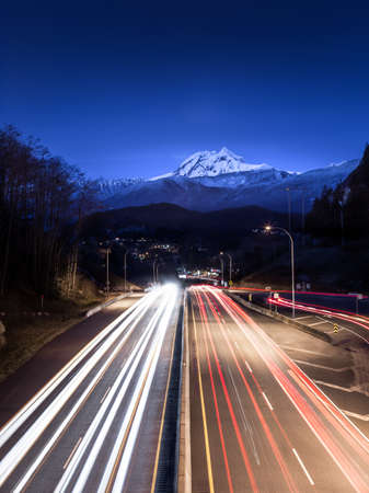 Highway with a snowy mountain peak in the background.の写真素材