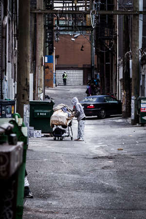 VANCOUVER, BC, CANADA - MAY 11, 2016: A vagrant with a shopping cart in Vancouvers Downtown Eastside.のeditorial素材
