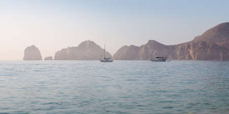 Sailboats in Cabo San Lucas harbor with the Arches in the background.の写真素材
