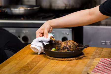 Roast chicken dish in a hot cast iron skillet.の写真素材