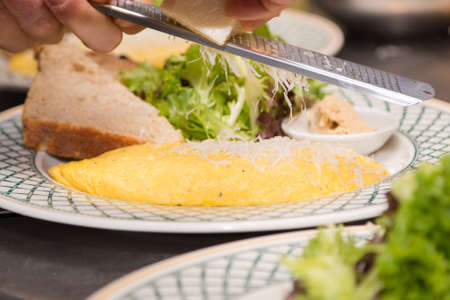 Omelette plate with parmesan being shaved on-top.の写真素材