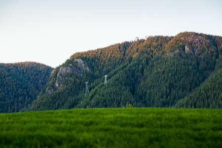 A view of Grouse Mountain, North Vancouver, lit by the setting sun.の写真素材