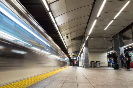Vancouver City Center station at evening rush hour with trains rushing by andのeditorial素材