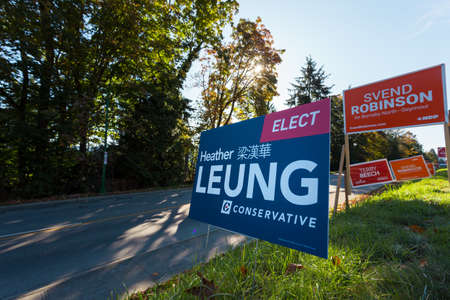 NORTH VANCOUVER, BC, CANADA - OCT 10, 2019: MP candidate signs beside the road rallying for voter support for their party in the upcoming Canadian Federal Election on Oct 21, 2019.のeditorial素材