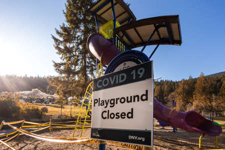 NORTH VANCOUVER, BC, CANADA - APR 11, 2020: A closed off playground in a North Vancouver public park lined with caution tape to aid in curbing the spread of the Covid 19 virus.のeditorial素材