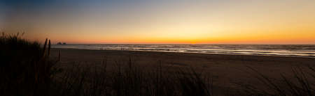 Oregon coast beach with a magnificent sunset and people taking a stroll