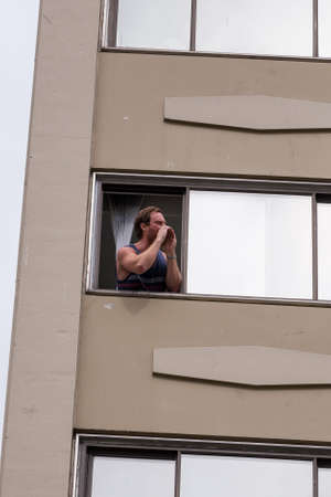 DOWNTOWN VANCOUVER, BC, CANADA - APR 26, 2020: Anti lockdown protesters march in defiance of the government imposed quarantine with onlookers heckle them from their apartments above.のeditorial素材