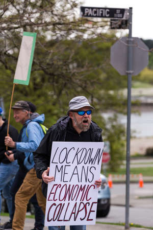 DOWNTOWN VANCOUVER, BC, CANADA - APR 26, 2020: Anti lockdown protesters march in defiance of the...