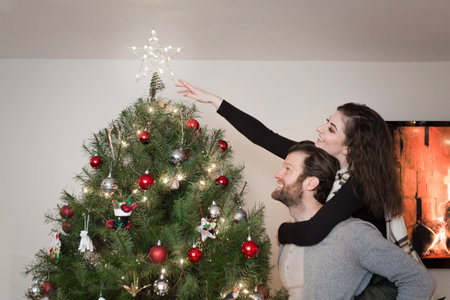 Young happy couple timelapse decorating Christmas tree.