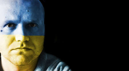 man with flag of Ukraine painted on his faceの写真素材