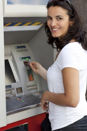 Woman inserts card in the ATMの写真素材