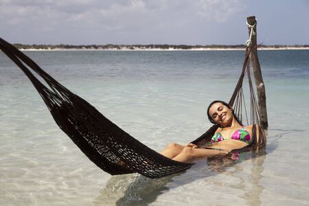 Woman lying in hammock in a seaの写真素材