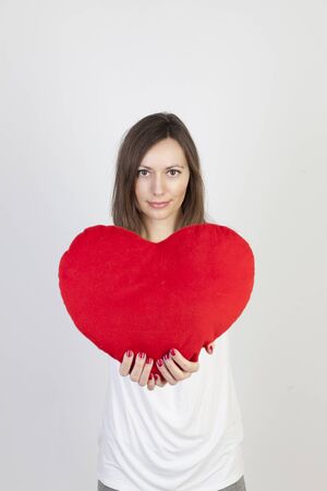 Young woman with a big red heart の写真素材
