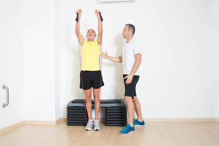 Coach helps senior with exercise