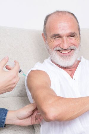 Elderly man having fun during vaccination