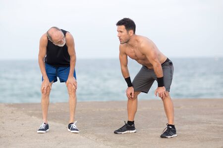 Senior man and coach tired after exerciseの写真素材