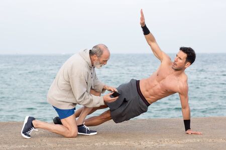 Coach explaining man freelectics exercise side plankの写真素材