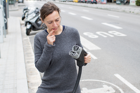 Woman having problems with electric car charger